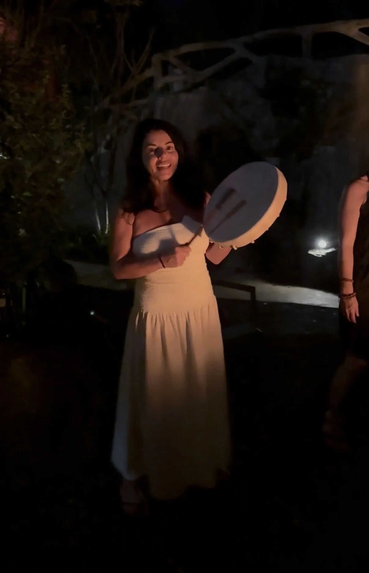 A woman with a drum by firelight