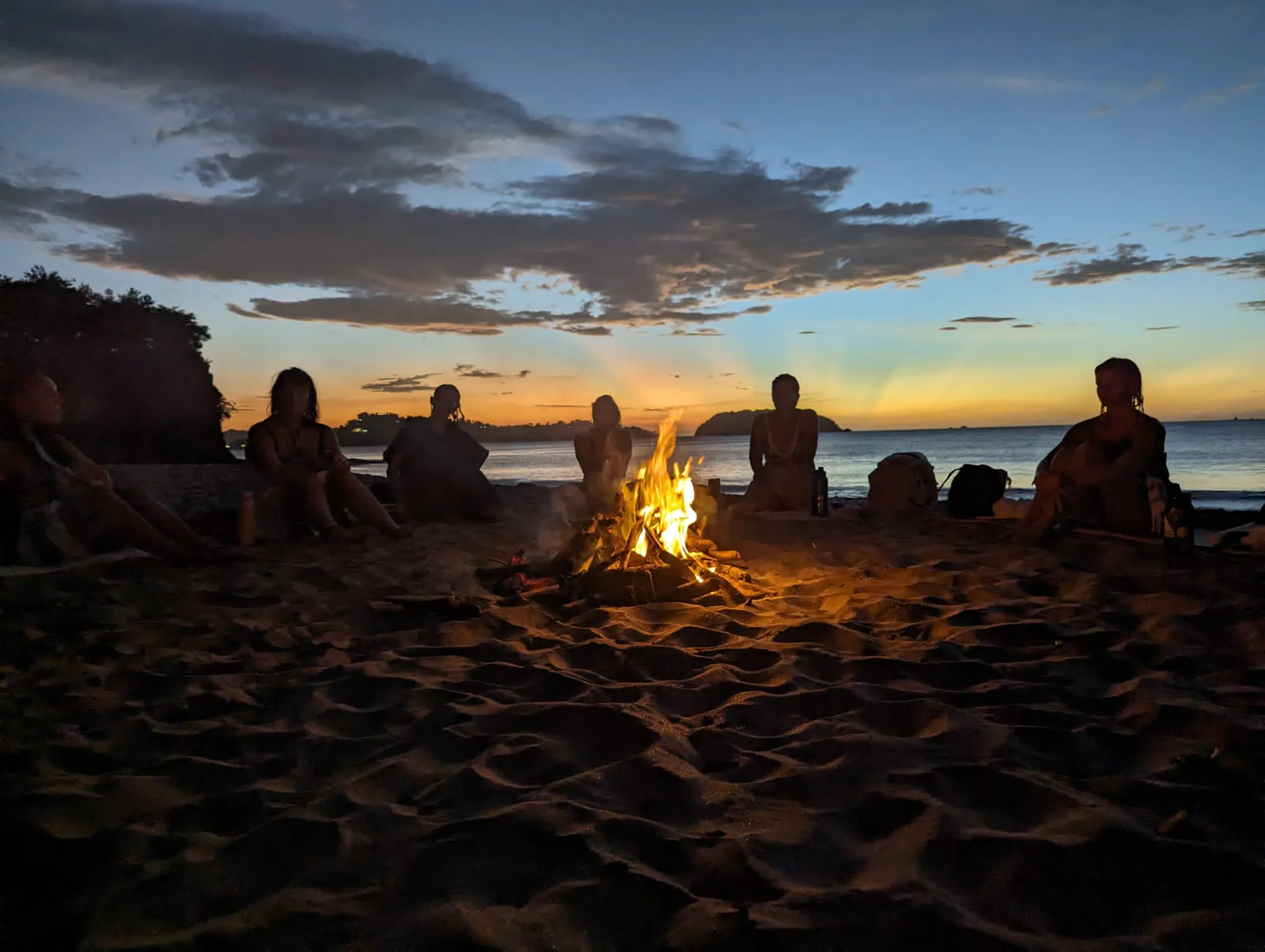 The circle gathered at the fire at dusk on Playa Junquillal